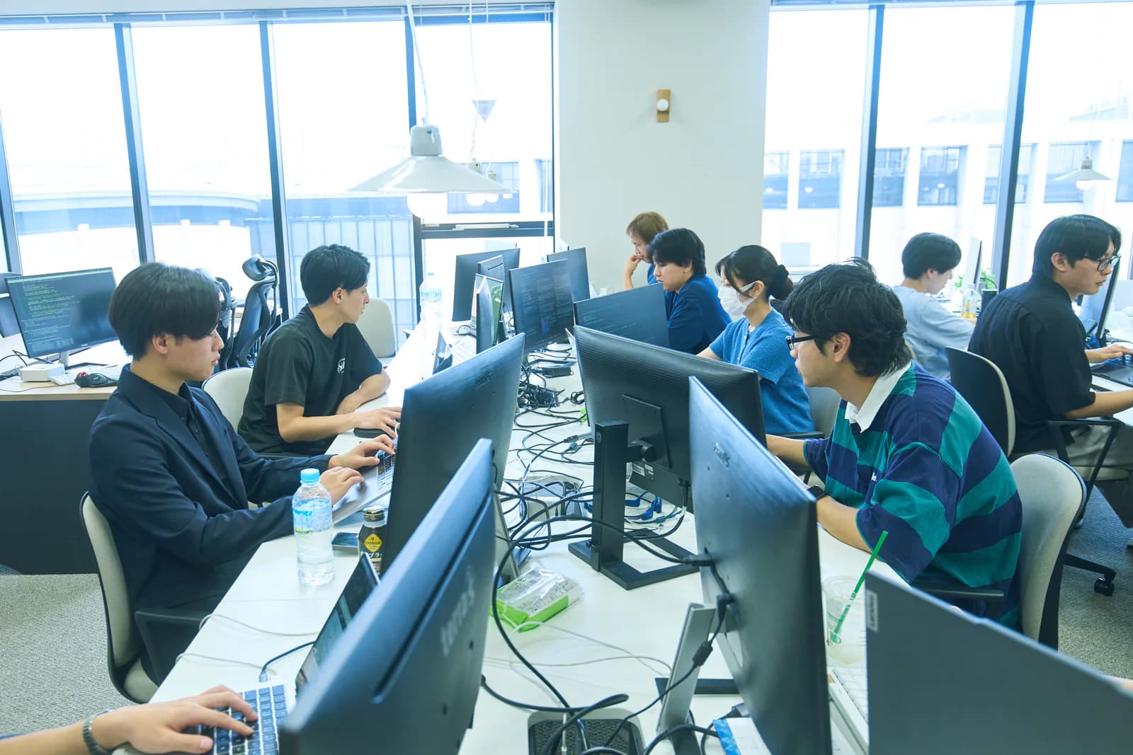 坂下淳一を含むメンバーがオフィスで業務を進める様子
