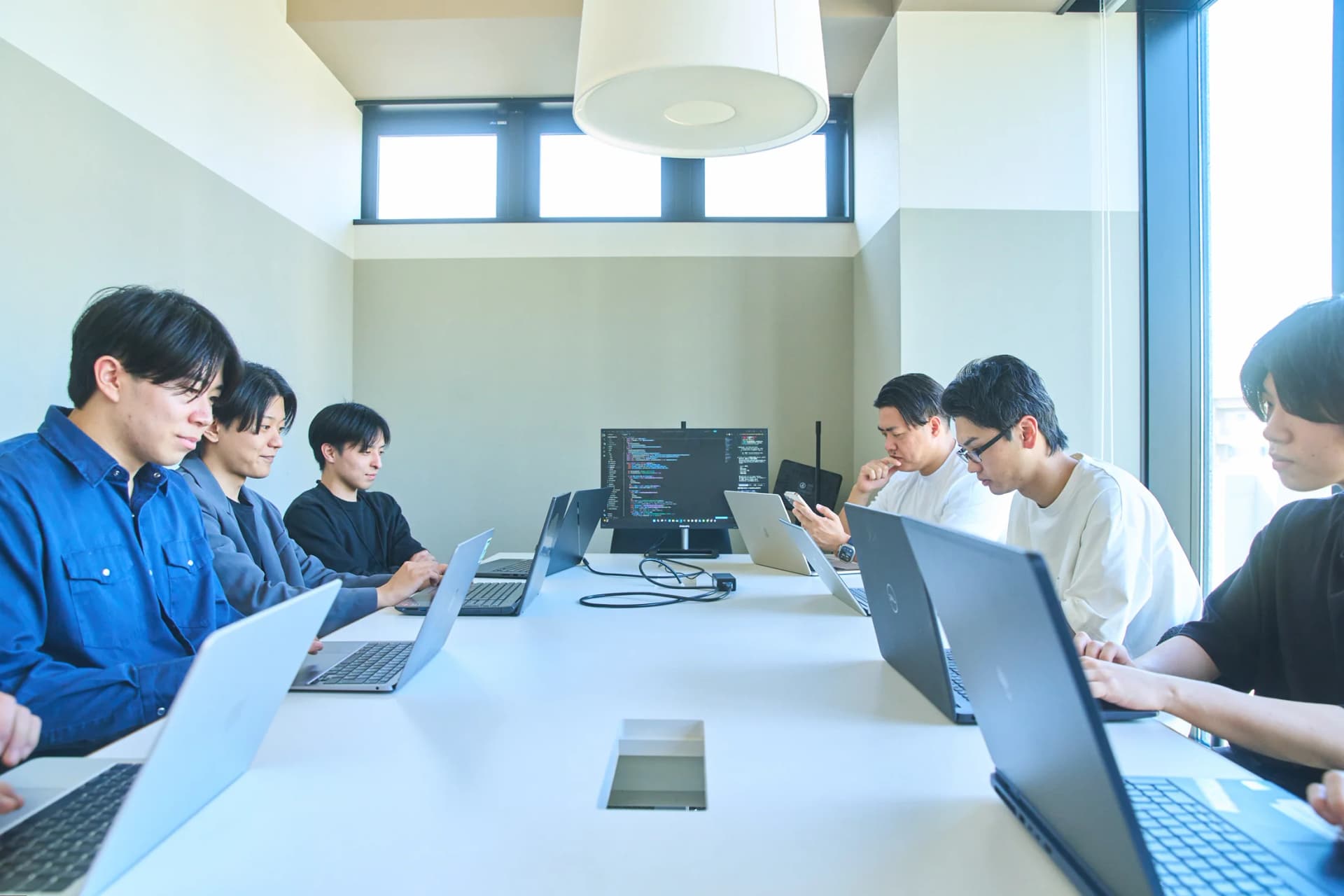 コードを表示したモニターを囲んで開発に取り組むプロパゲートのAI開発チーム