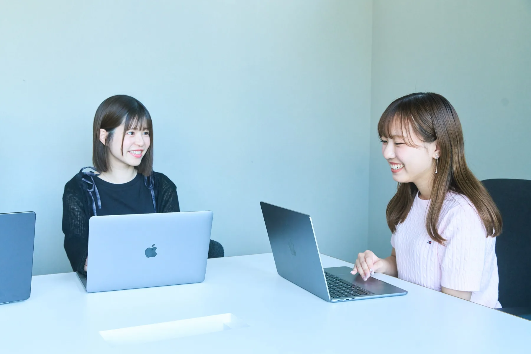 パソコンを開き、Webサイト制作について話し合うプロパゲートのメンバー
